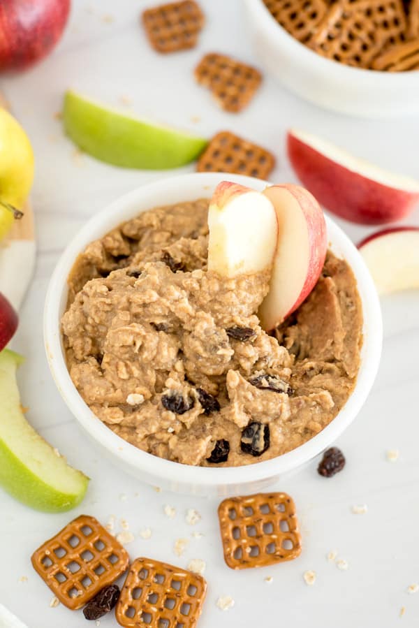 white bowl of oatmeal raisin cookie dough dip with apple slices
