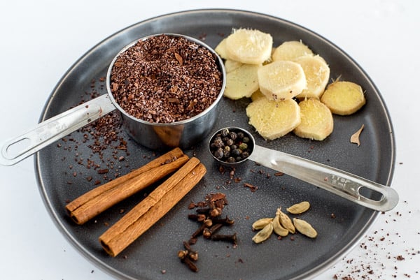 black plate with ginger, cinnamon, cloves, and cardamom