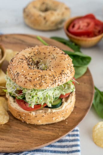 chicken with green sauce on a bagel with tomato and spinach