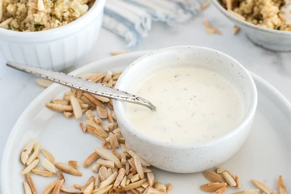 Yogurt dill sauce in a white bowl with a spoon