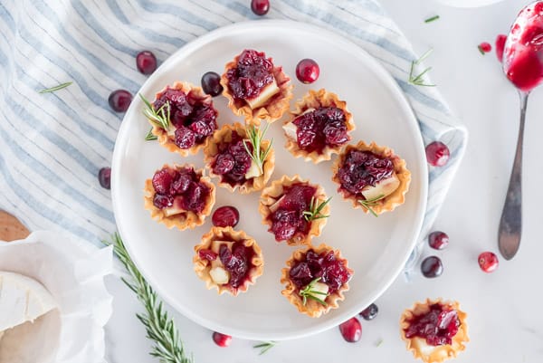 red cranberry apple brie bites on a white plate