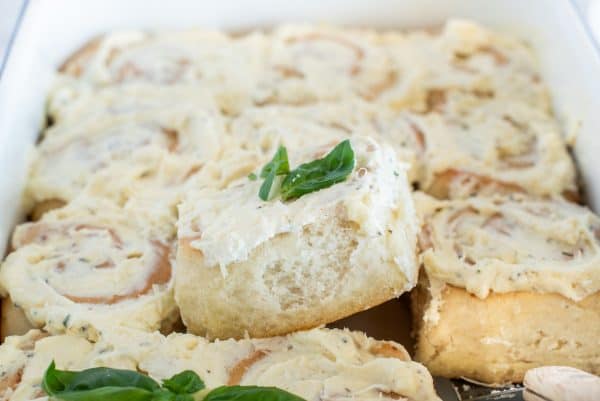 Garlic butter swirl rolls with cream cheese topping in a pa