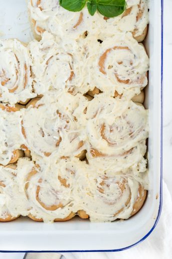 Garlic butter swirl rolls with cream cheese topping in a pa