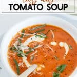 Tomato soup with cream and basil in a white bowl
