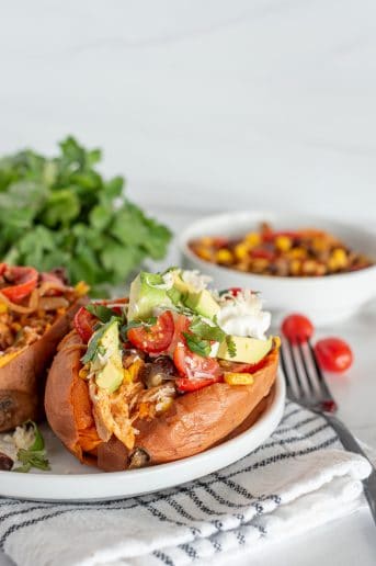 Sweet potato stuffed with chicken and peppers topped with fresh avocado, tomatoes, and sour cream.