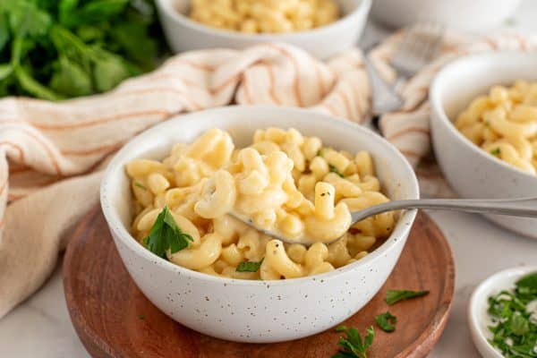 creamy mac and cheese in a white bowl with a fork