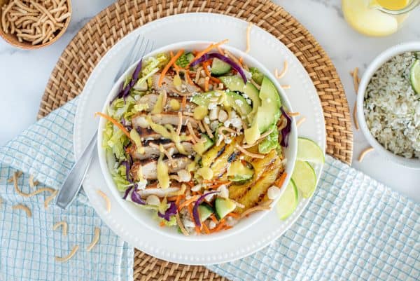 Chicken Salad with cabbage, carrots, pineapple, and mango dressing in a white bowl
