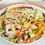 Chicken Salad with cabbage, carrots, pineapple, and mango dressing in a white bowl